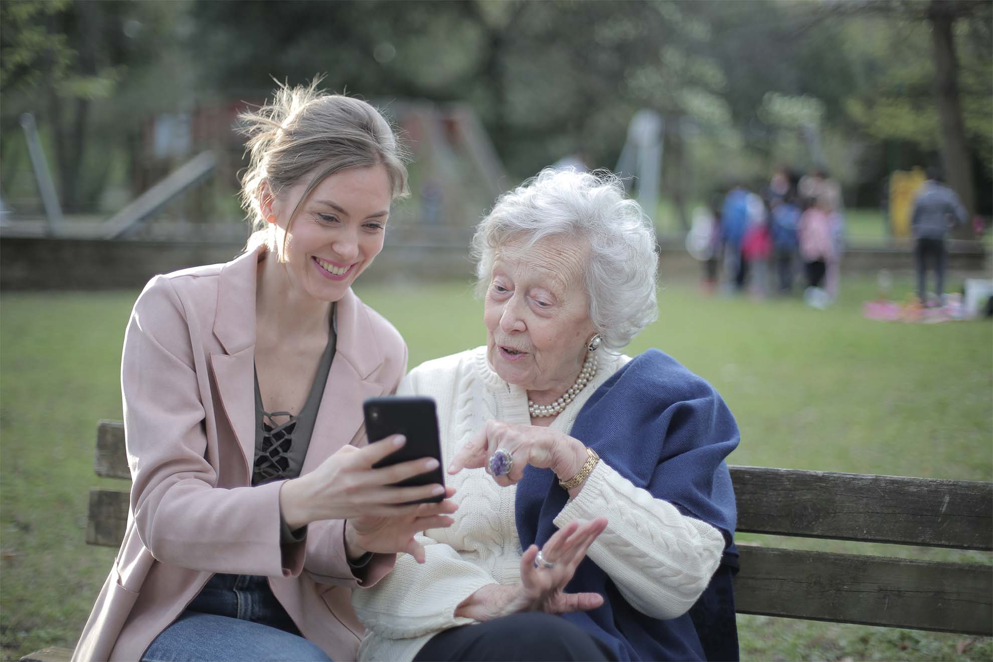 resident with carer sat on a park bench
