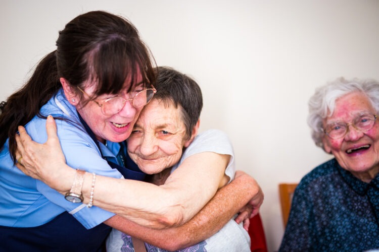 Carer hugging resident