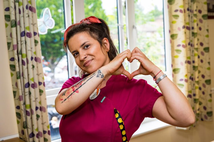 Caregiver making heart with hands