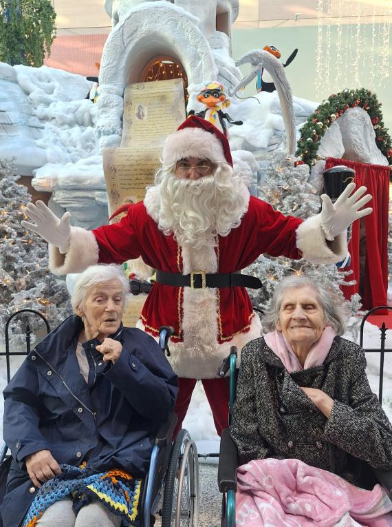 santa clause posing for a picture with residents on a day trip out